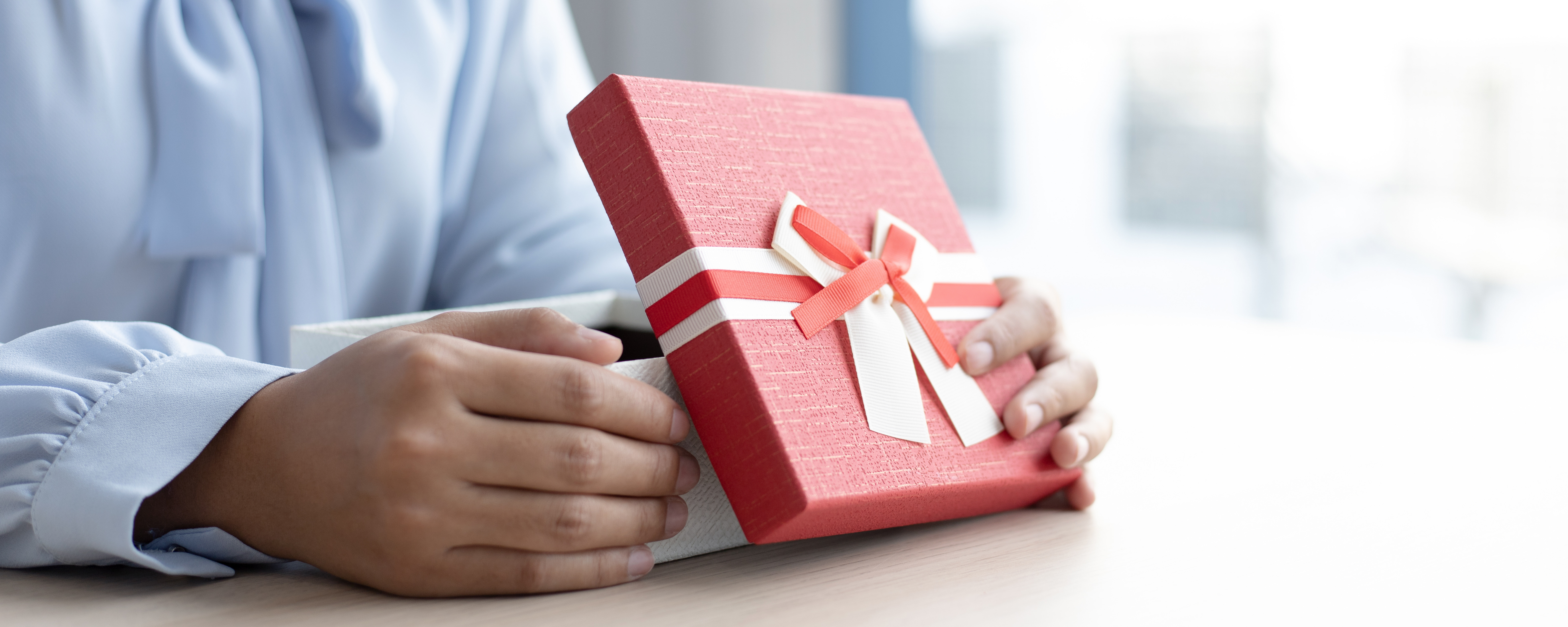 Image depicting a gift being opended, related to the blog showing gift tax planning strategy for transferring wealth to children and grandchildren